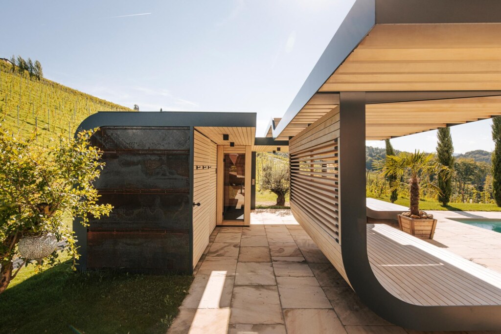 Außensauna in ein Poolhaus eingebaut, mit Sichtschutz, Liegeflächen, harmonisch eingebettet in einen Garten am Weinberg.