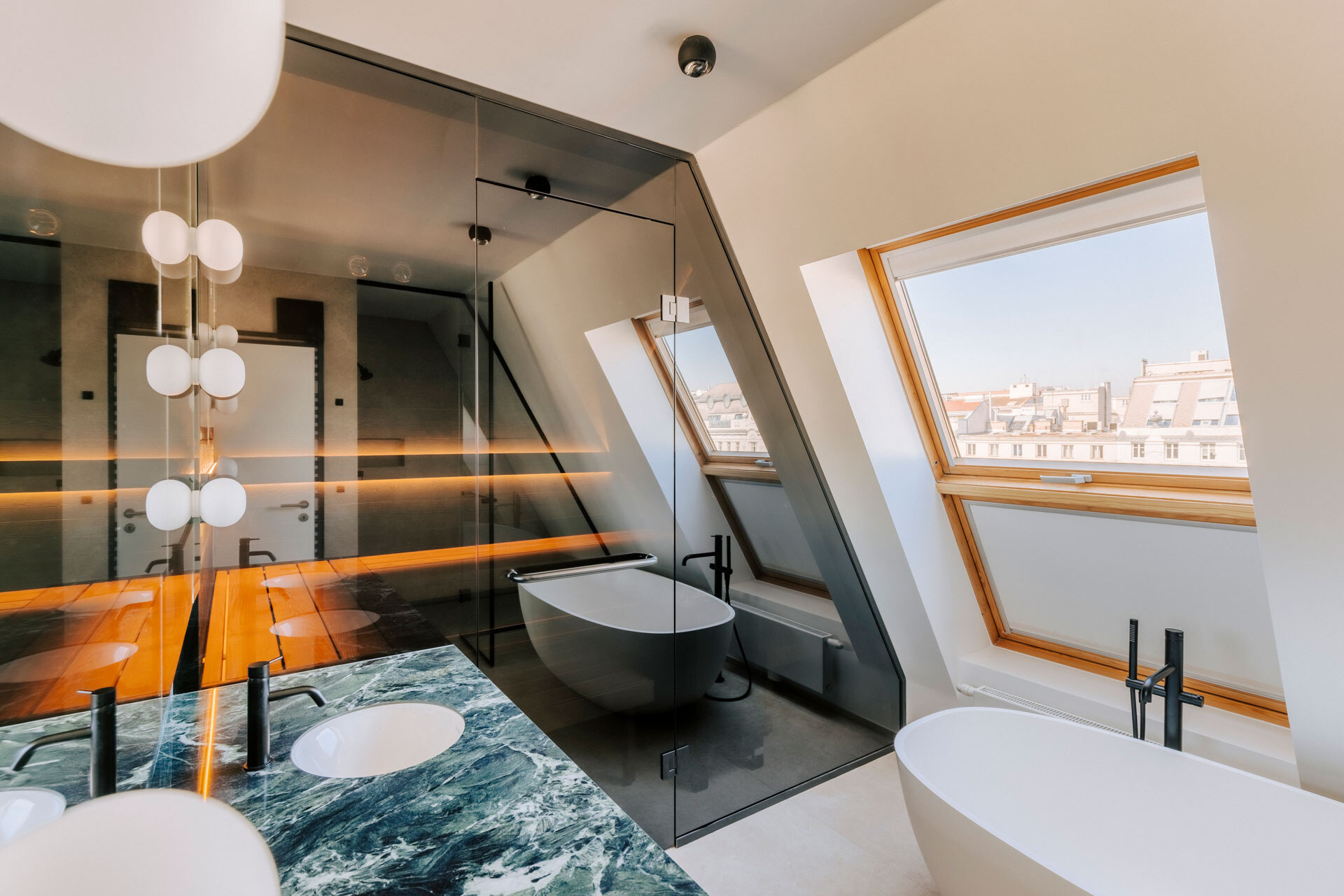 Dunkel verglaste Design-Sauna aus Thermofichte mit anschließendem Marmorwaschtisch und freistehender Badewanne in einem luxuriösen Bad einer Wiener Dachgeschosswohnung.