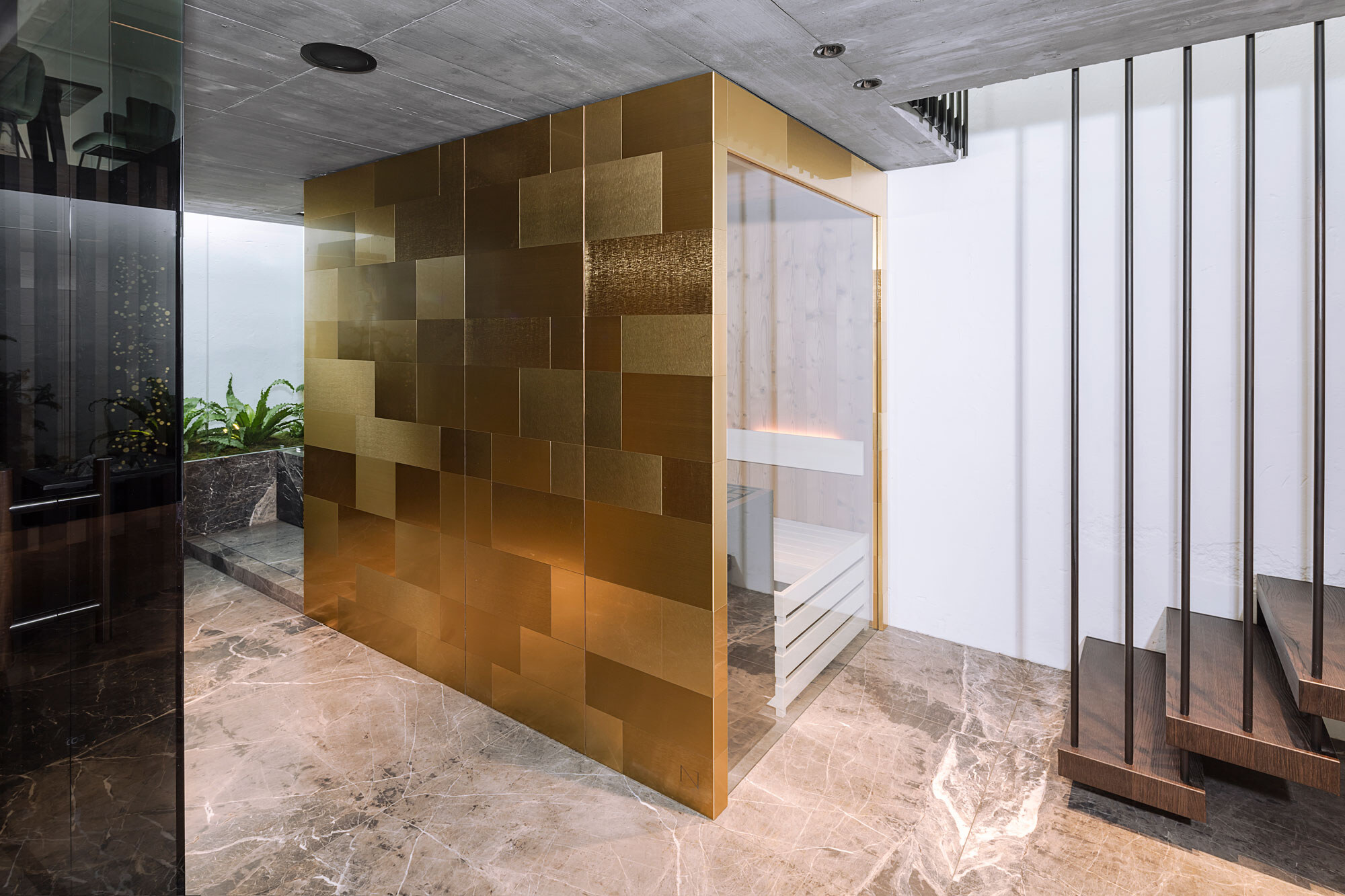 Goldene Designer Sauna im Sale vom Saunahersteller Deisl, außen verkleidet mit gebuersteten Metallfliesen inklusive einer unsichtbar integrierten Saunatuere und einem großen Panoramafenster.