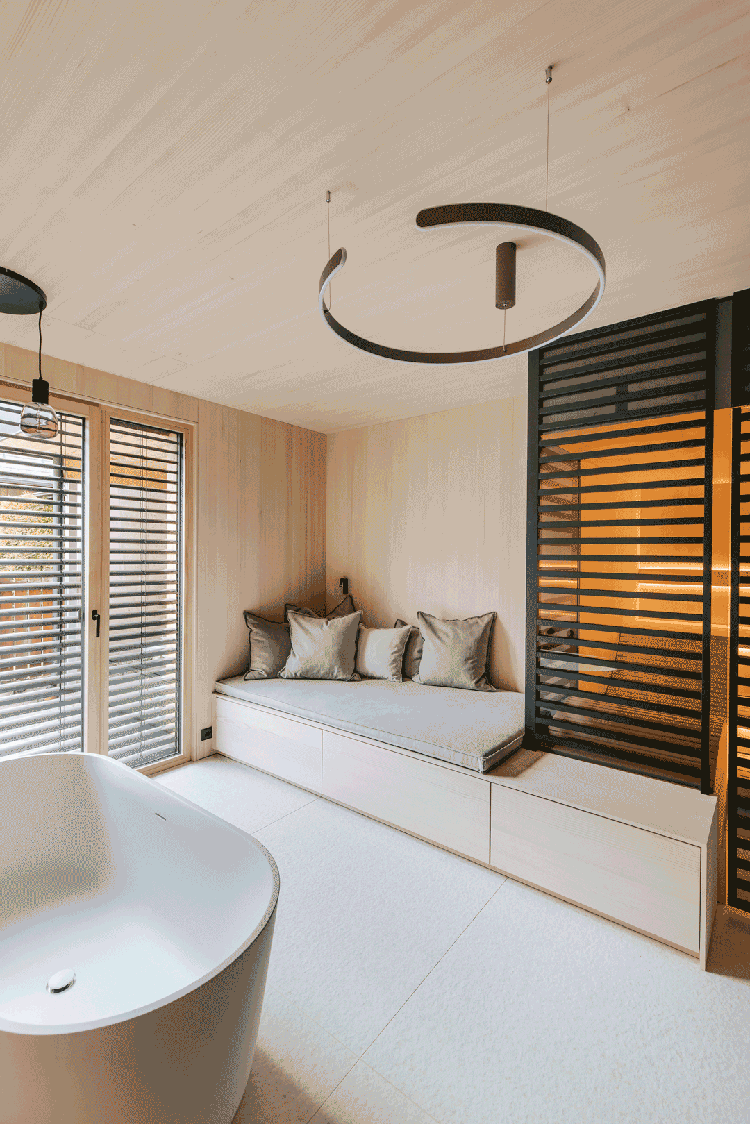 Massgeschneiderte Sauna in einem modernem Badezimmer mit anschliessendem Daybed und integriertem Stauraum.