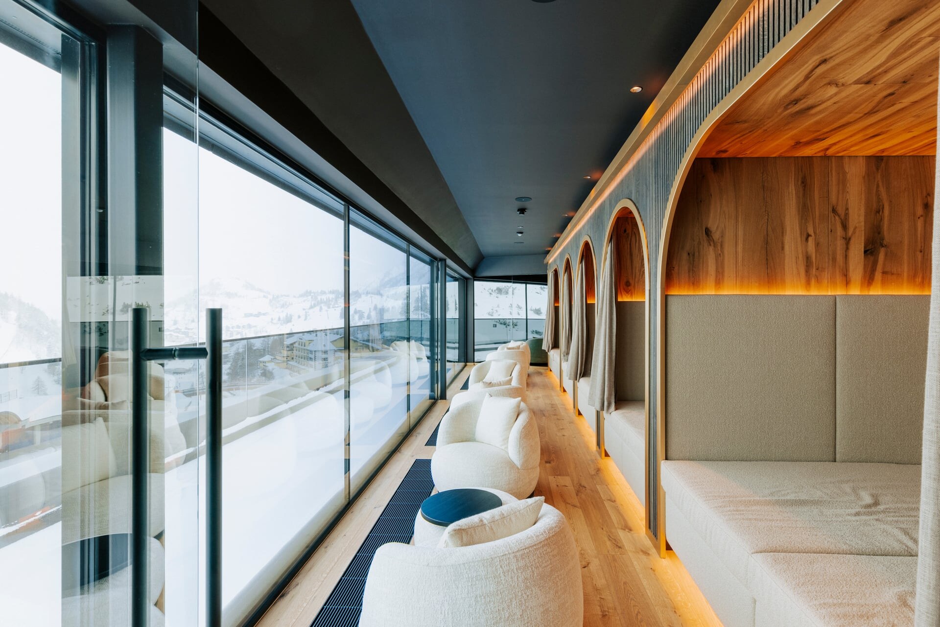 Eleganter Ruhebereich mit Kojen un Blick auf die Skipiste im Hotel Steiner in Obertauern.