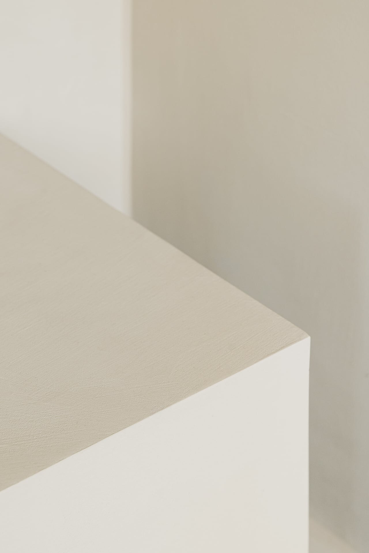 Bankdetail einer minimalistischen Dampfdusche aus hellgrauem, fugenlosen Mikrozement.