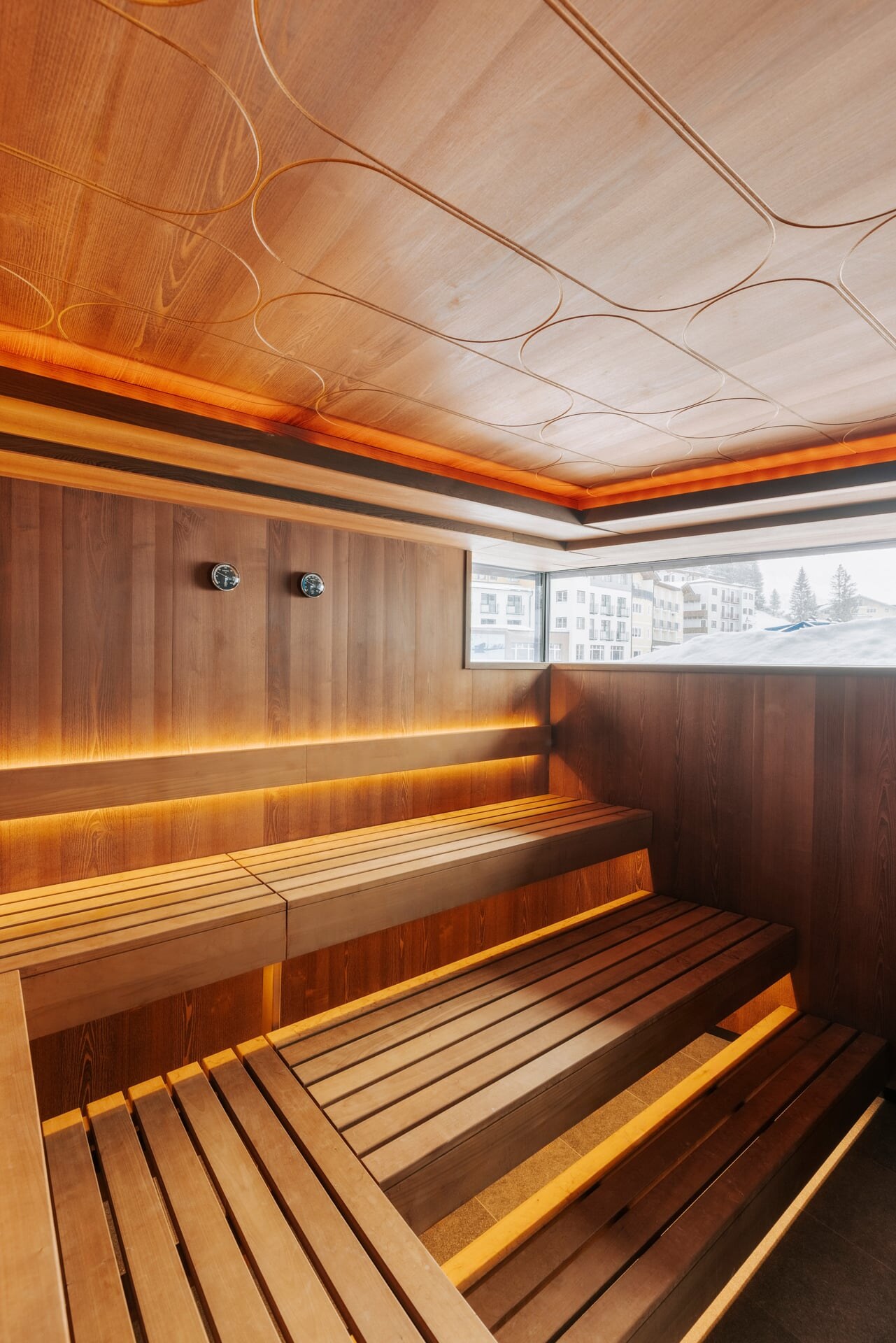 Moderne Luxus-Sauna aus dunklem Akazienholz mit einer Decke mit dekorativem Muster.