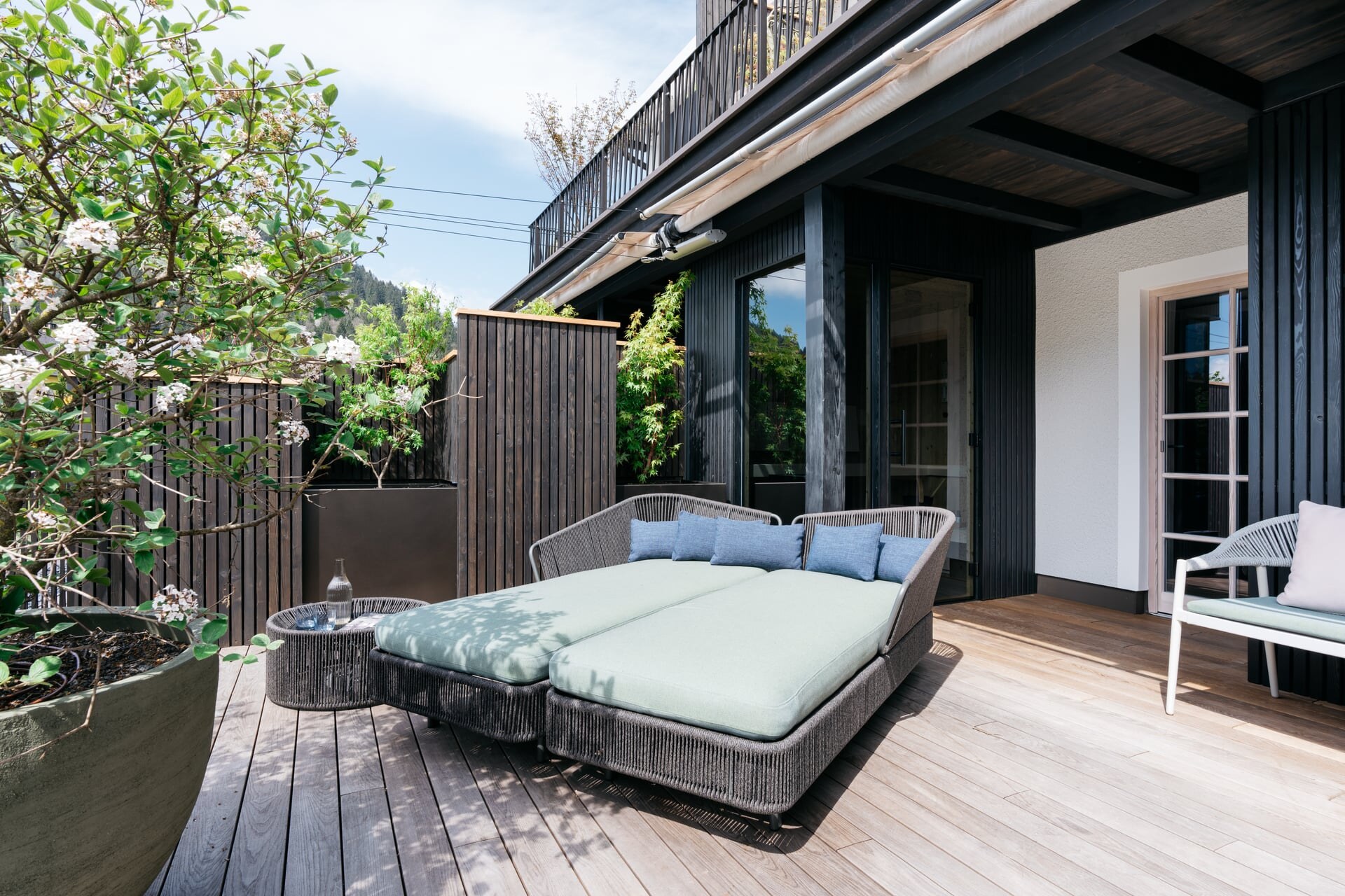 Modere Outdoor-Sauna auf der Terrasse mit schwarzer Holzfassade und Glaselementen im Refugium Lunz.