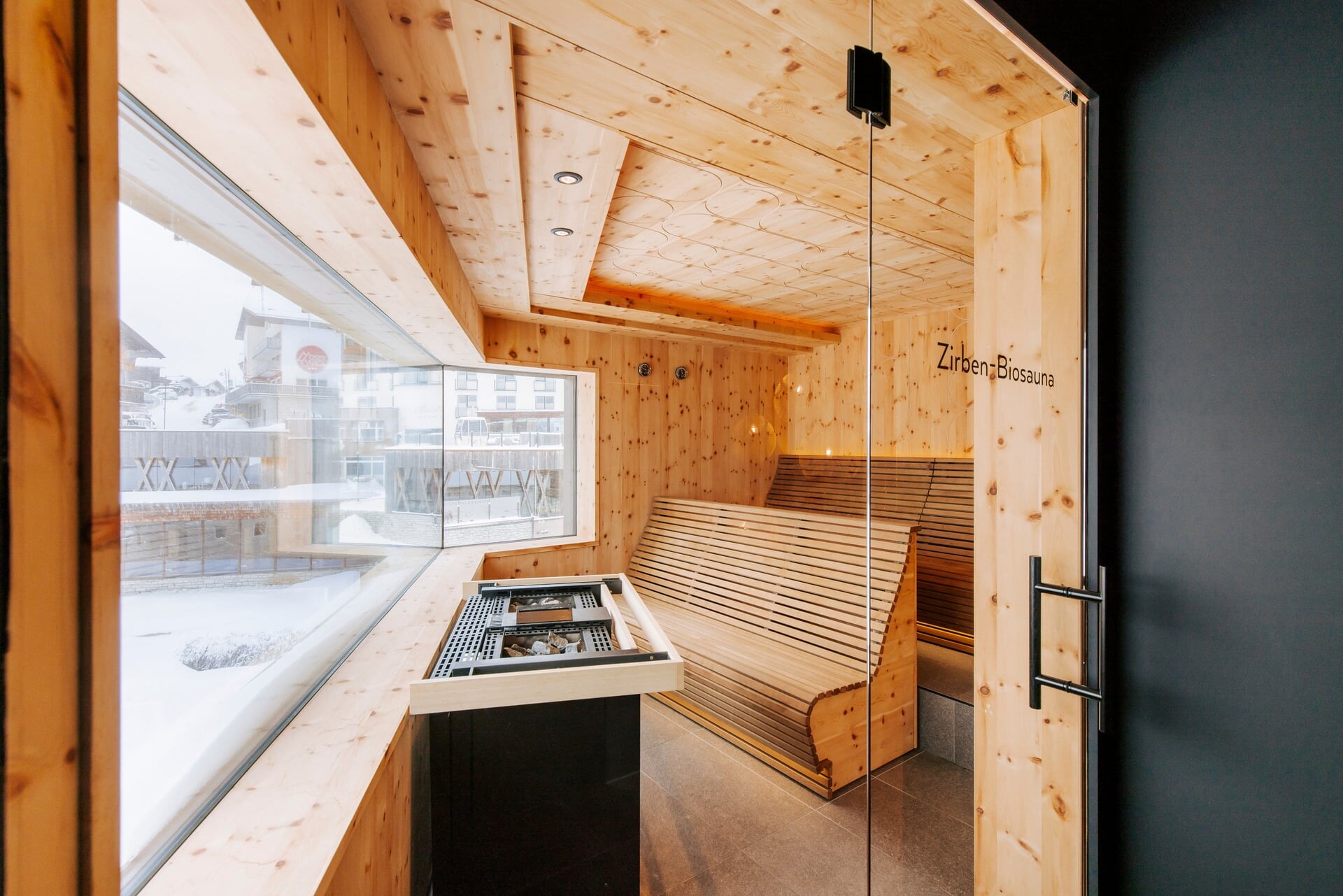 Moderne Zirnebsauna mit Panoramafenster, ergonomischen Bänken und Biosaunaofen im Superior Hotel Steiner.