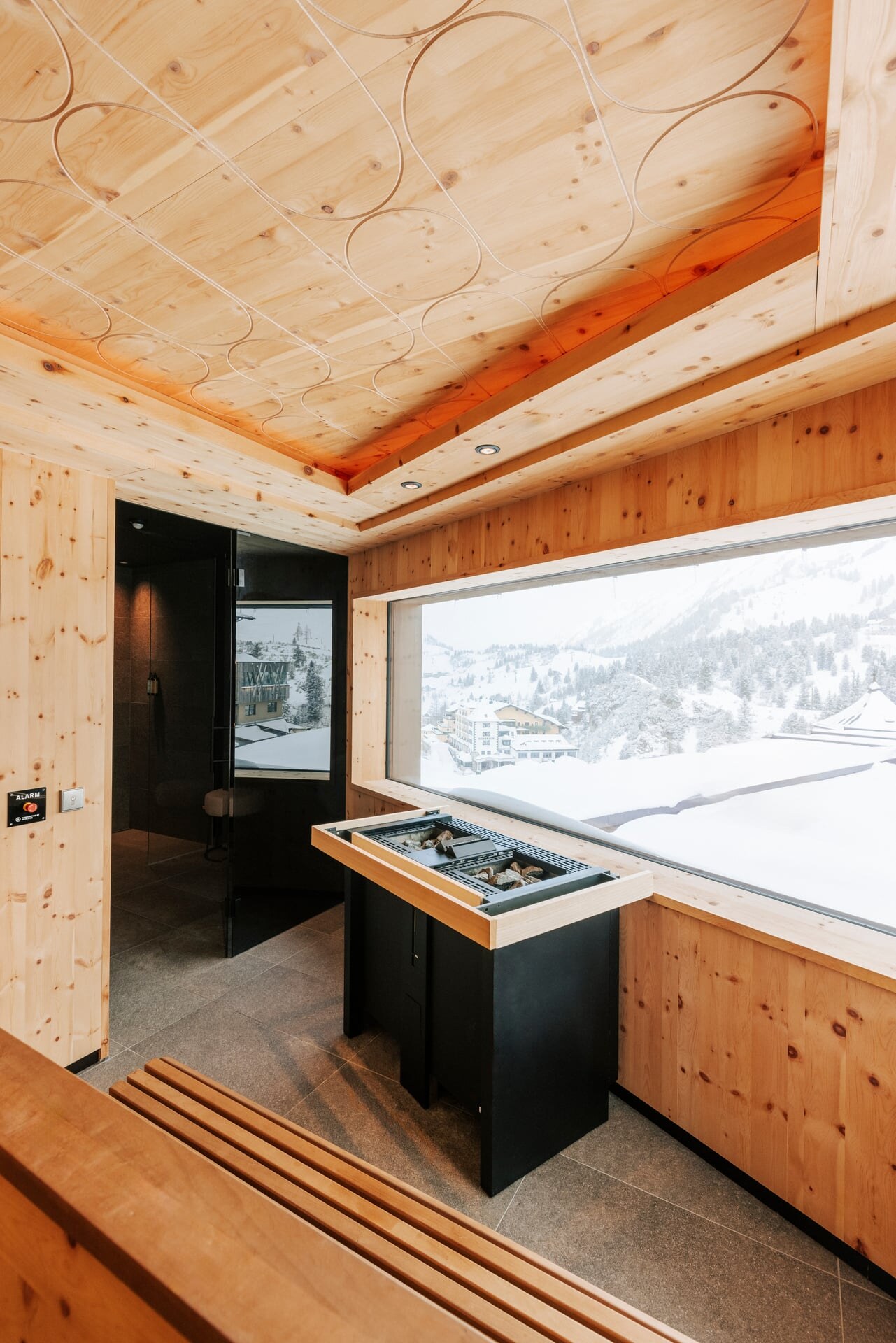Moderne Zirnebsauna mit Panoramafenster und Ausblick auf das Skigebiet Obertauern im Wellnessbereich des Hotel Steiner.