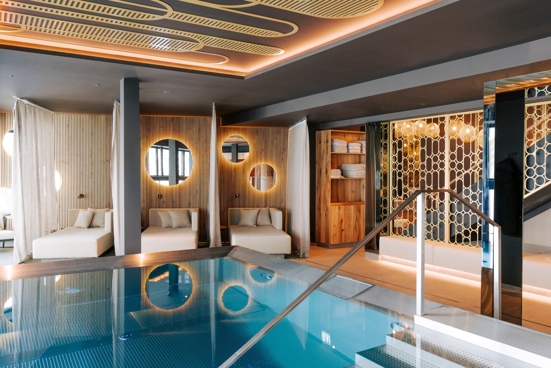 Moderner Wellnessbereich mit Indoorpool und Ruheekojen im Berg Spa des Hotel Steiner in Obertauern.