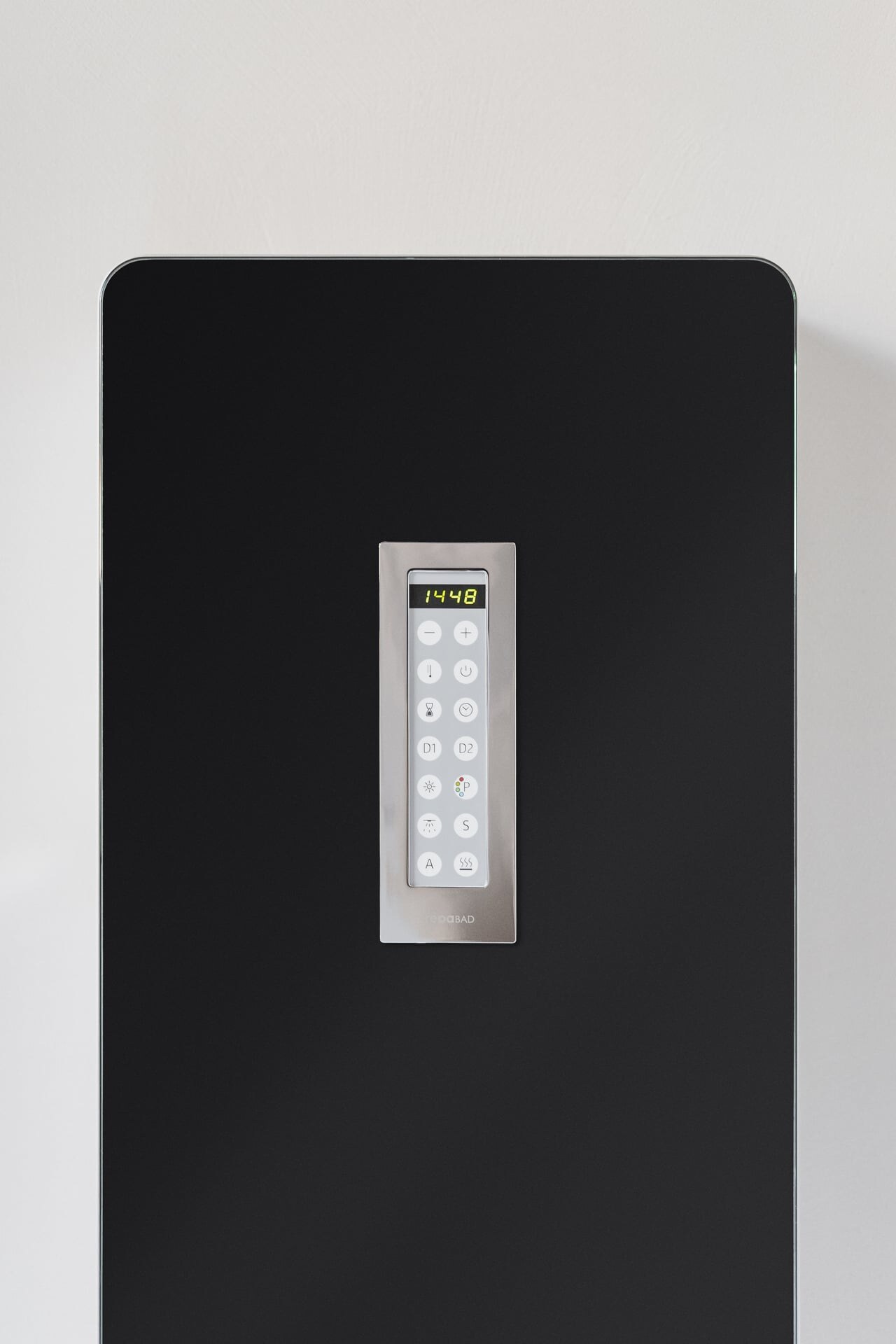 Detail eines modernen, schwarzen Dampfmoduls mit integriertem Dampfgenerator in einer minimalistischen Dampfdusche aus hellgrauem, fugenlosen Mikrozement.