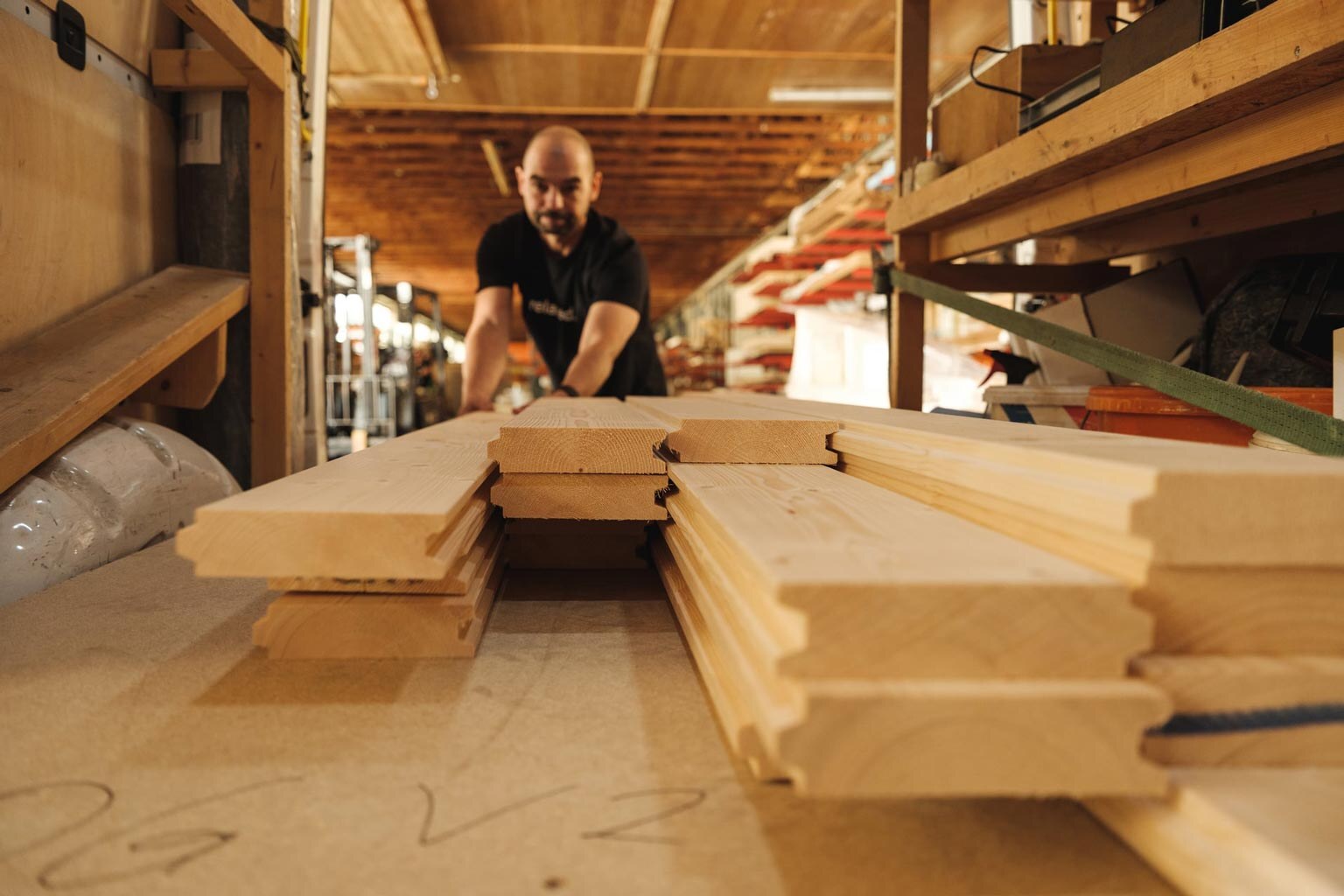 Deisl Monteur beim Einsortieren von Blockbohlen.