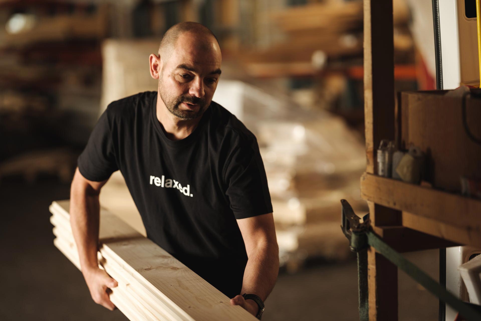 Deisl Monteur beim Einsortieren von Blockbohlen.