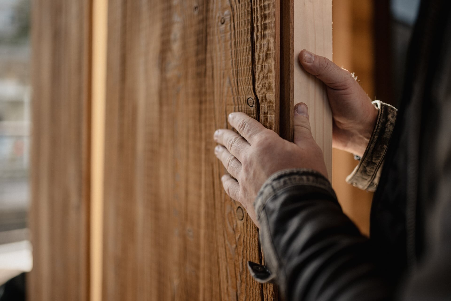 Detail eines Monteurs bei der Saunamontage einer Seitenwand.