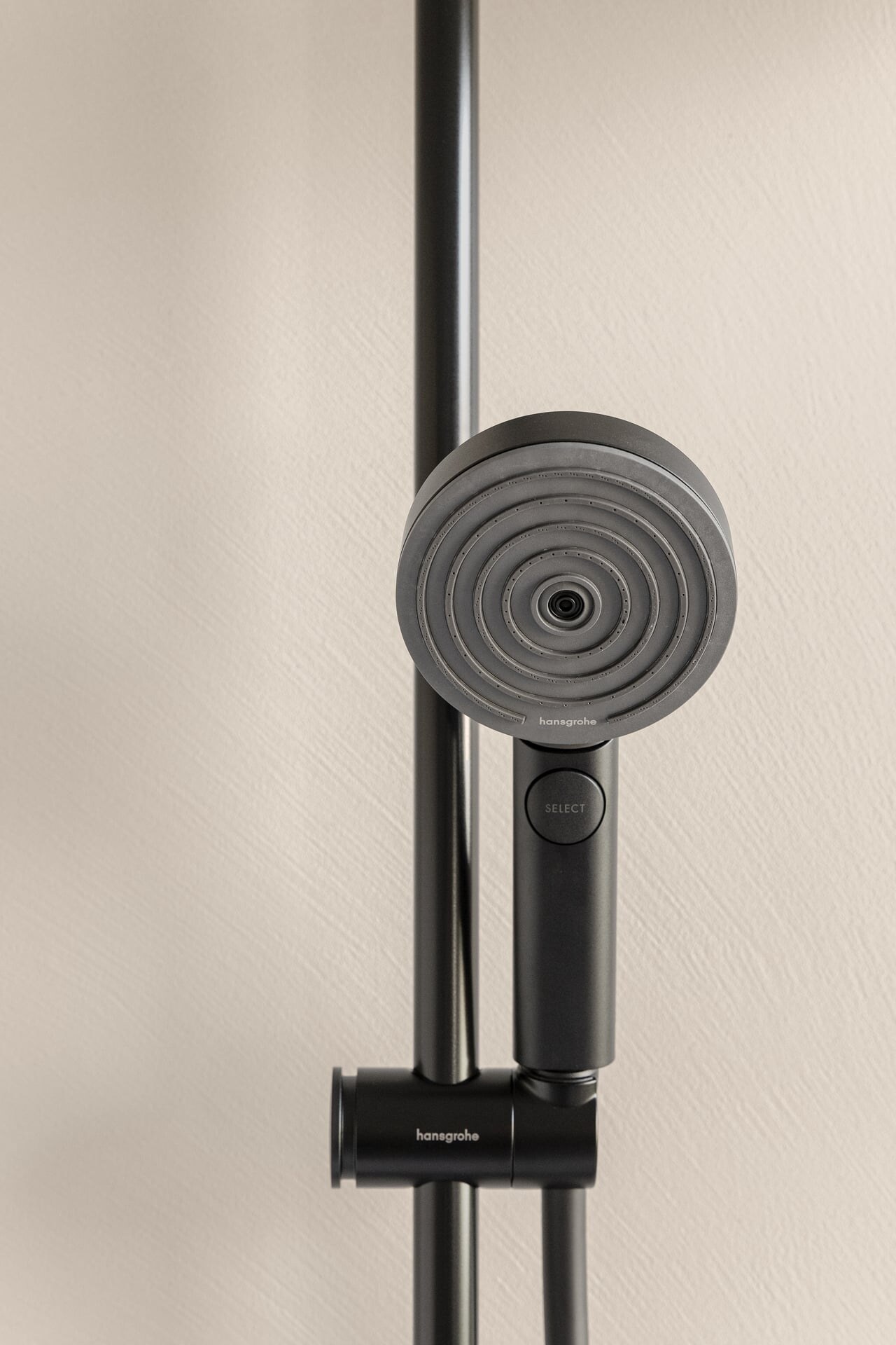 Detail einer modernen, schwarzen Dusch-Armatur in einer minimalistischen Dampfdusche aus hellgrauem, fugenlosen Mikrozement.