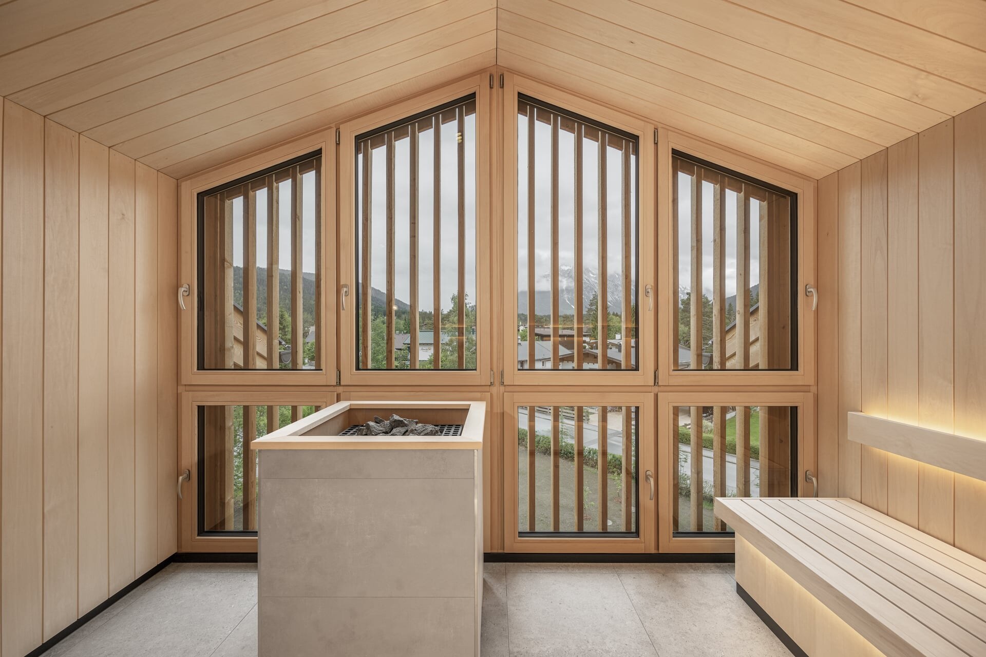 Moderne Sauna unter dem Dachgiebel des Naturhotel Kurblhof mit großem Panoramafenster.