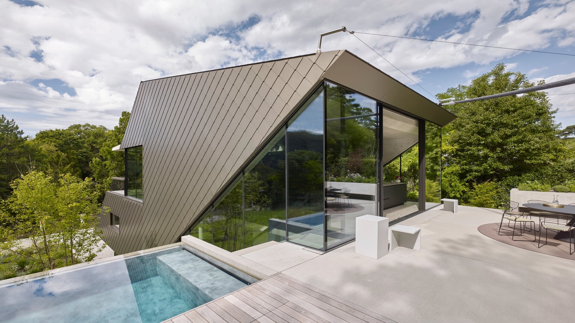 Offener Outdoor-Wellnessbereich mit moderner Architektur und Infinity-Pool.