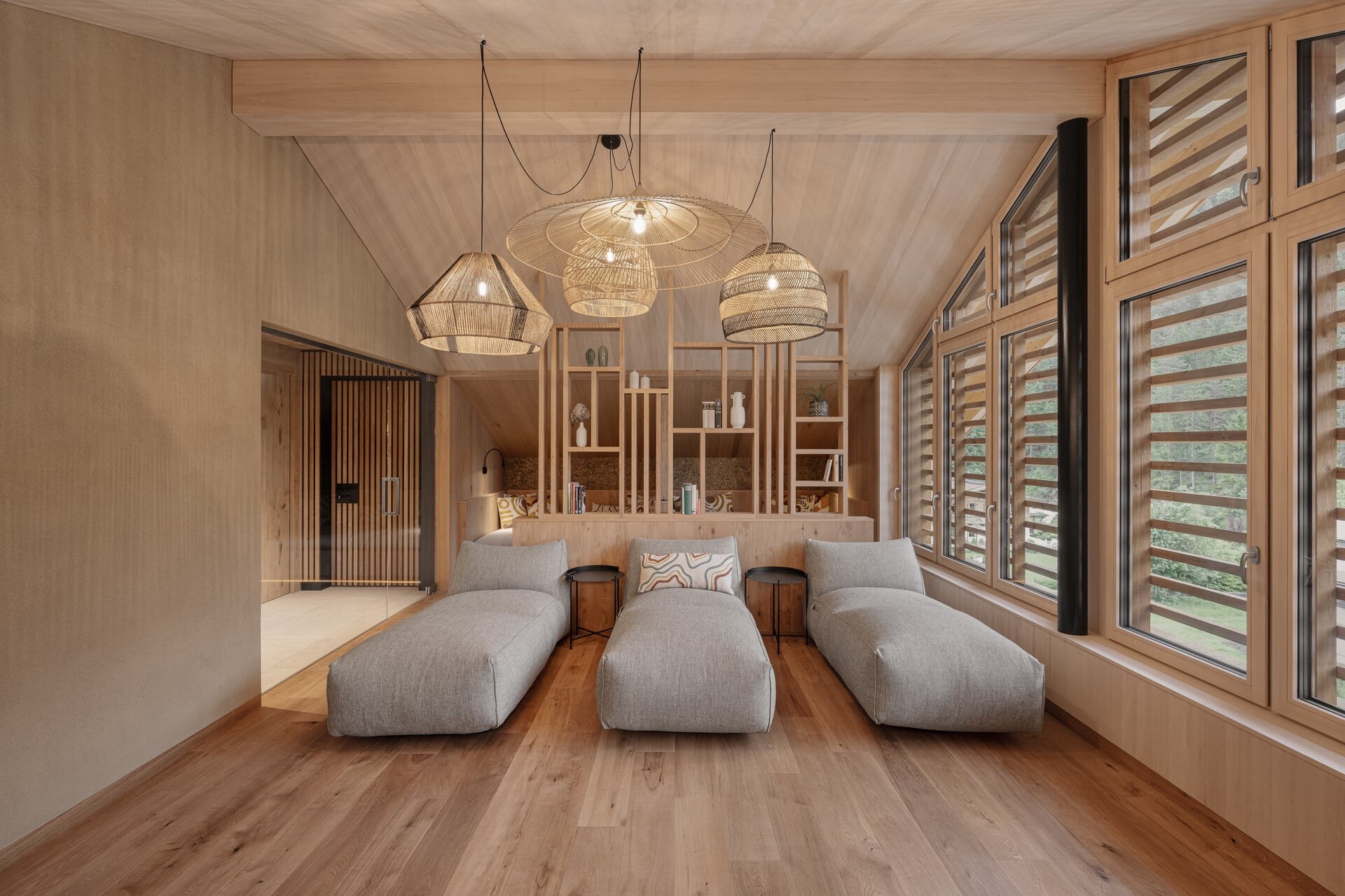 Moderner Ruhebereich aus Holz mit Daybeds unter einer Dachschräge im Naturhotel Kurblhof.