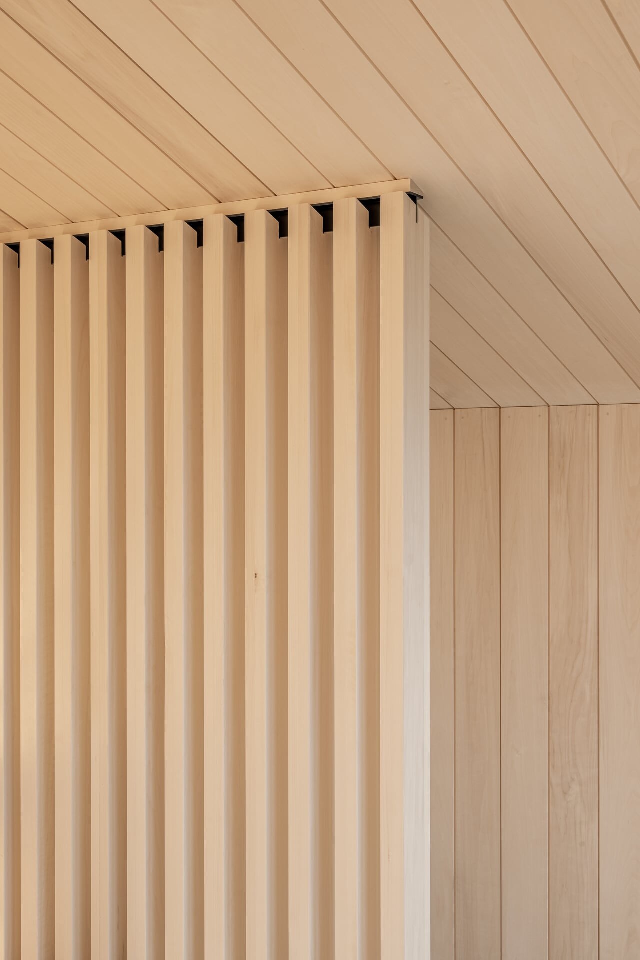 Deteil eines Sichtschutz-Element aus Holzlamellen in einer Sauna aus hellem Espenholz.