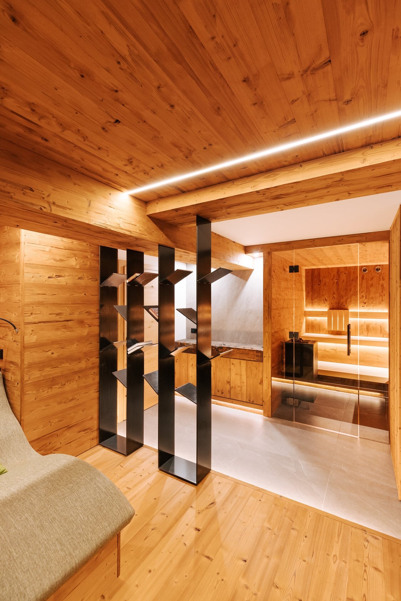 Moderne Sauna im Private Spa in alpinem Design mit minimalistischer Magazinablage als Raumteiler und Sichtschutz.