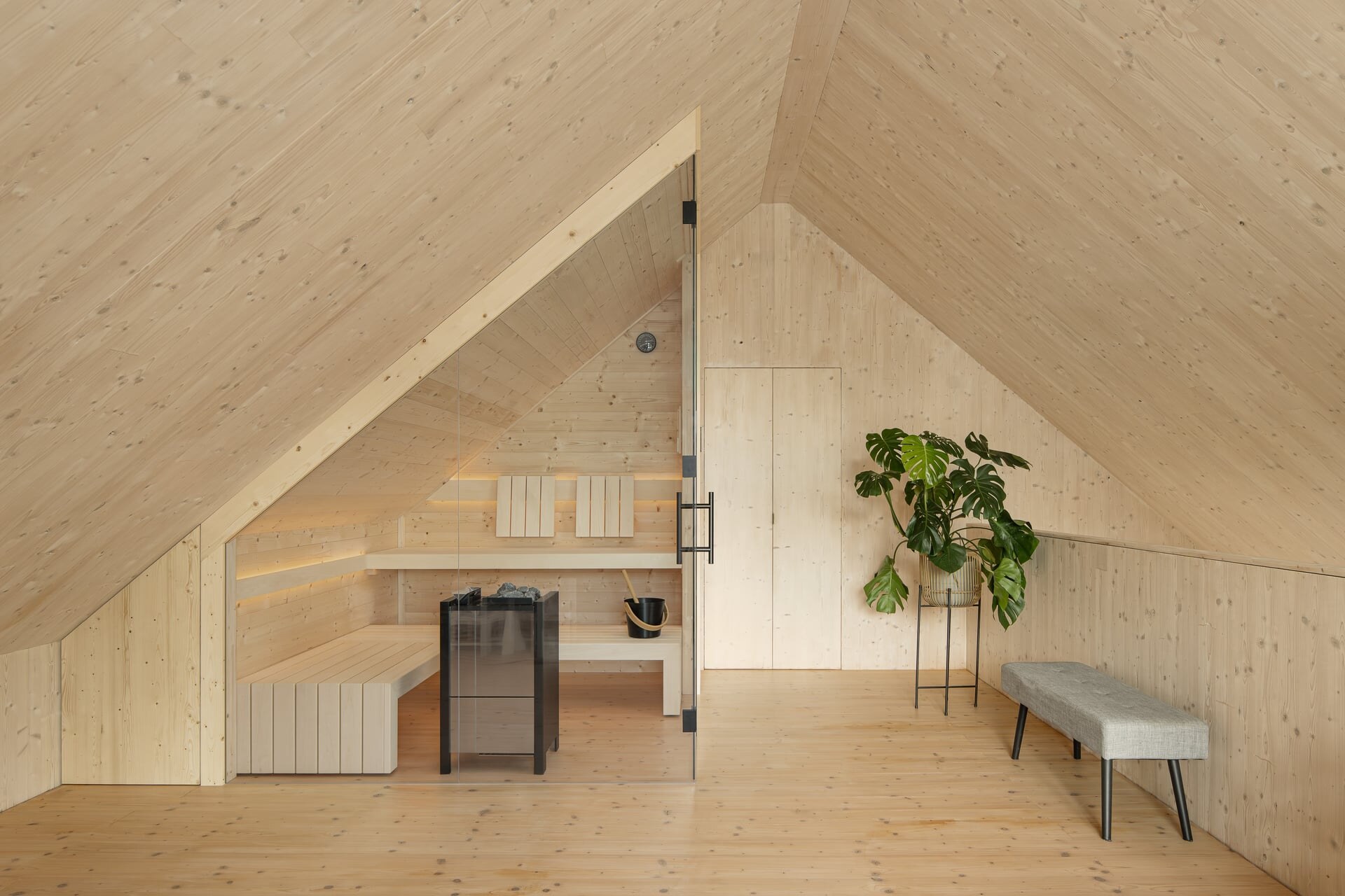 Moderne Sauna mit Glasfront im Dachgeschoß eines minimalistischen Architektenhauses in hellem Fichtenholz.