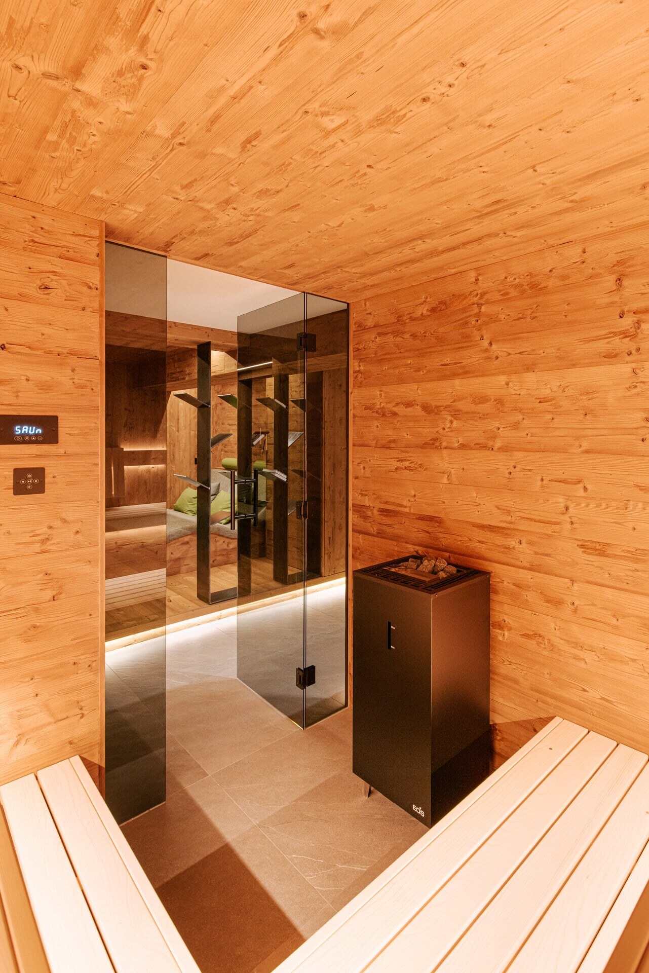 Moderne Sauna mit rustikalem Touch aus gehacktem Fichtenholz in einem Wellnesskeller.