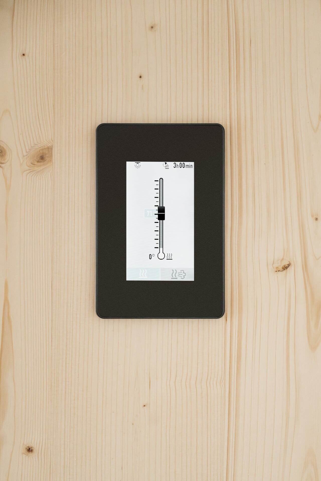 Schwarze Saunasteuerung in elegantem Design mit Touchdisplay integriert in eine Sauna aus hellem Fichtenholz