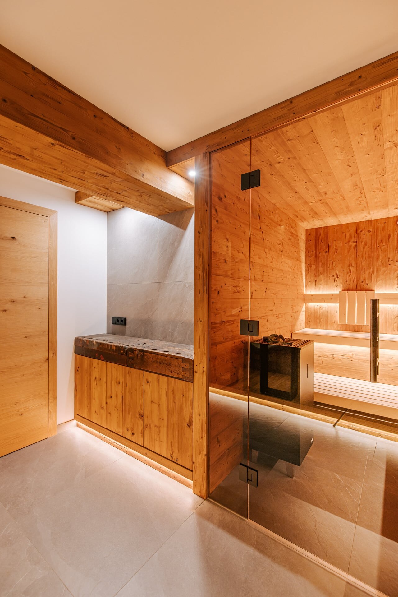 Moderne, verglaste Sauna in rustikalem Stil integriert in eine Kellenerische mit anschließender Wasser- und Vitaminbar.