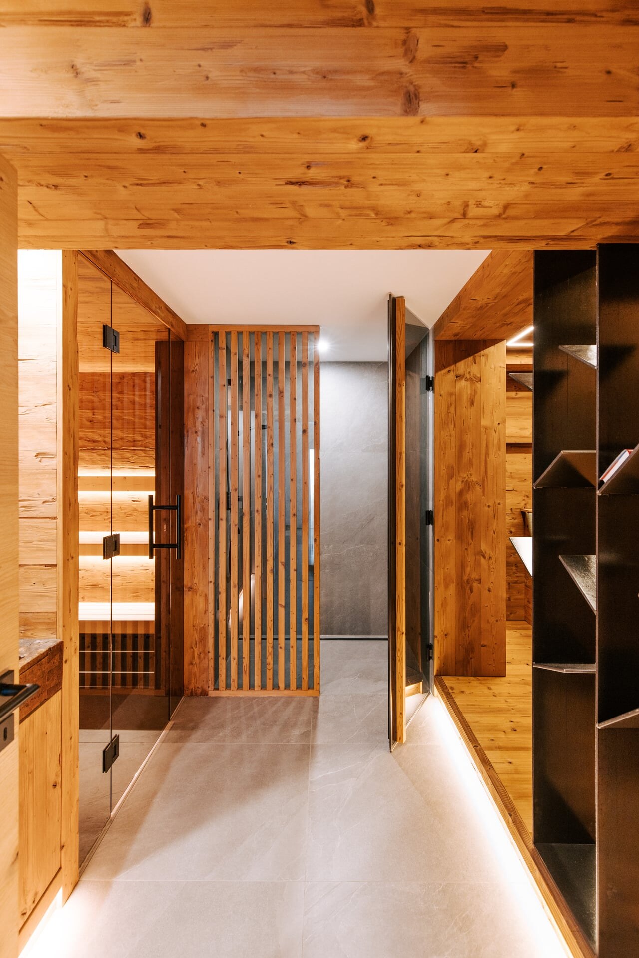 Moderner Wellnesskeller miut rustikalem Flair, einer verglasten Sauna und bodenebener Dusche.