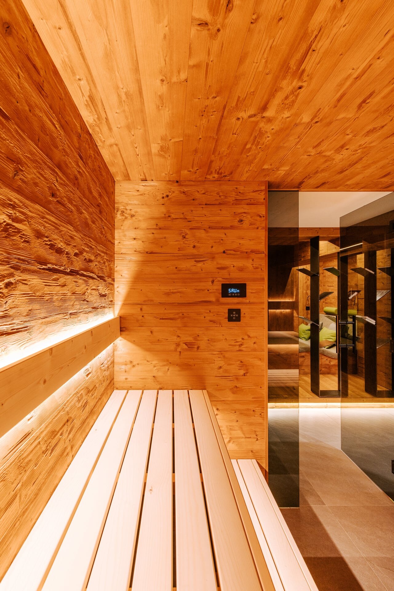 Moderne Sauna in rustikalem, gehacktem Fichtenholz und Blick in den Wellnesskeller.