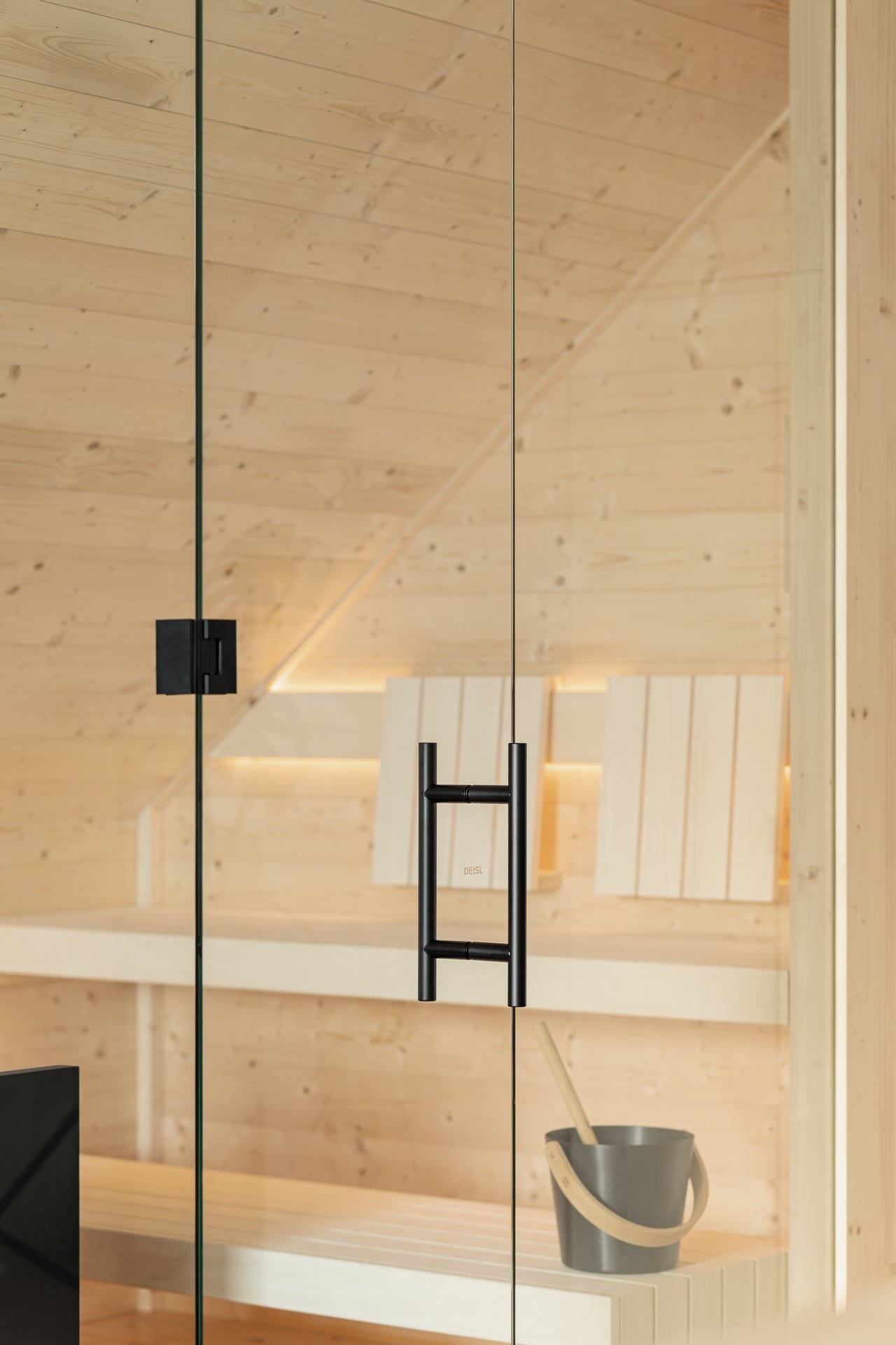 Maßgeschneiderte, puristische Sauna aus hellem Fichtenholz mit Glasfront integriert in eine Dachschräge
